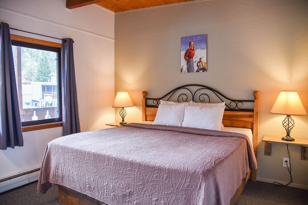 Neatly made bed in a room at Alpine Lodge in Red River