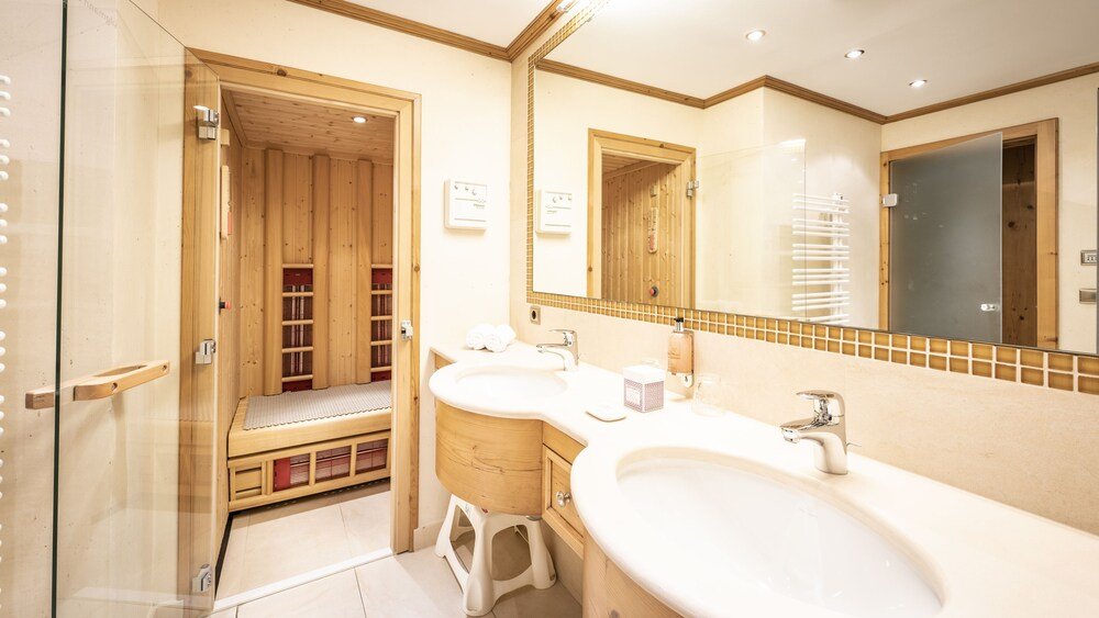 Bathroom with wood paneling at Anthonys Alpin Hotel in Lech