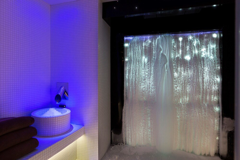 Baño con bañera y azulejos blancos impecables