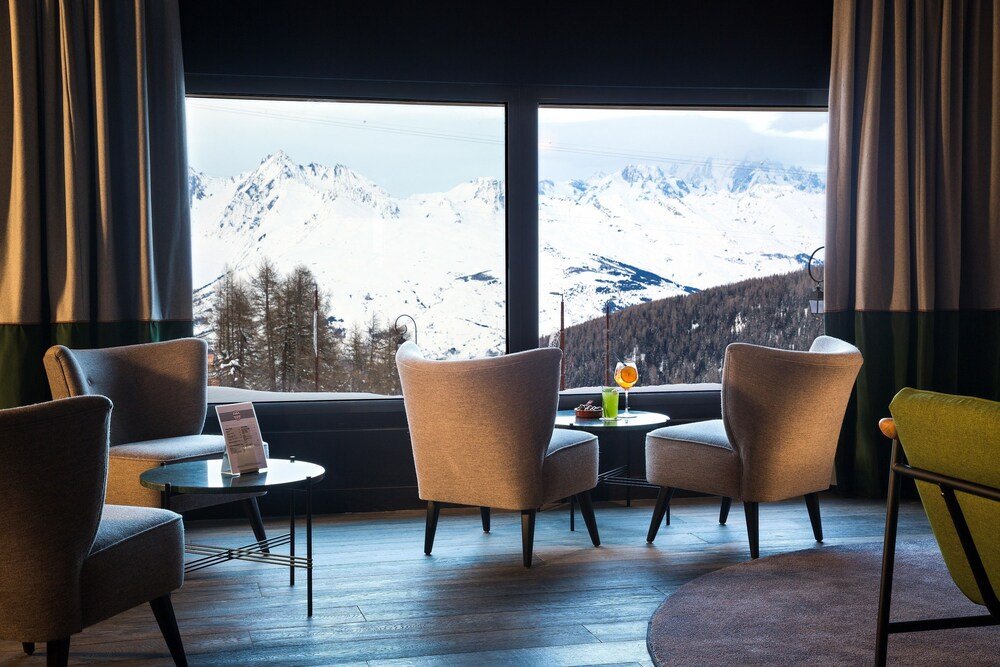 Habitación con ventana y vista a las montañas nevadas