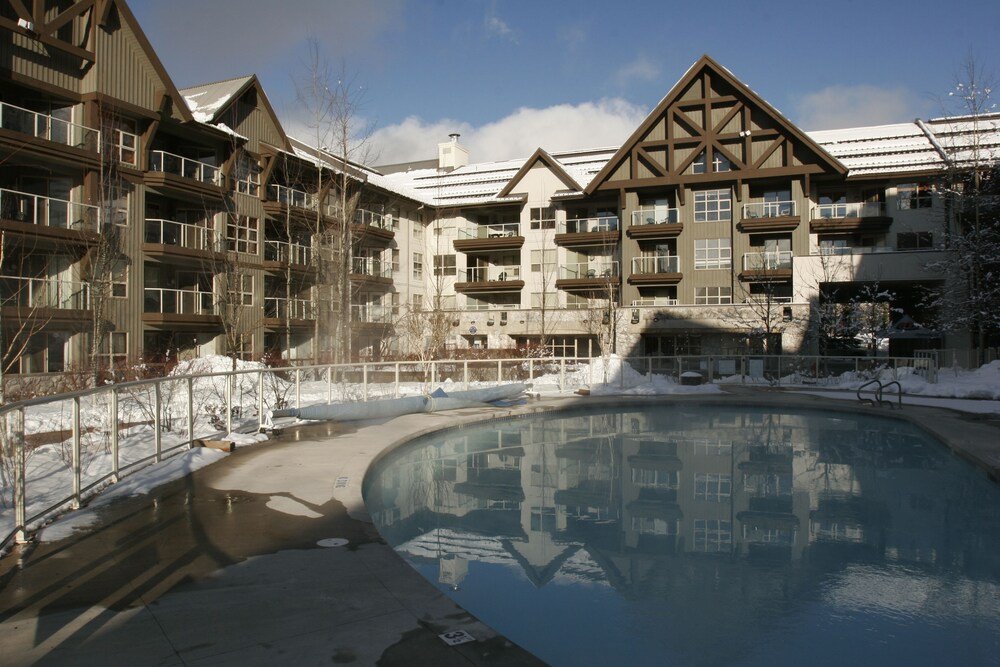 Multi-story condo building with a snowy entrance in Whistler