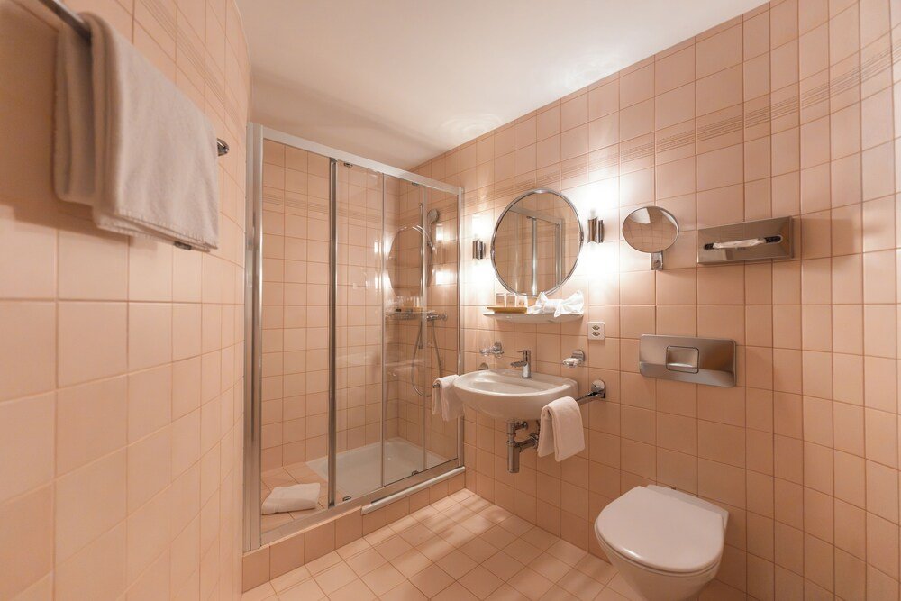 Baño con ducha de cristal en una habitación del hotel