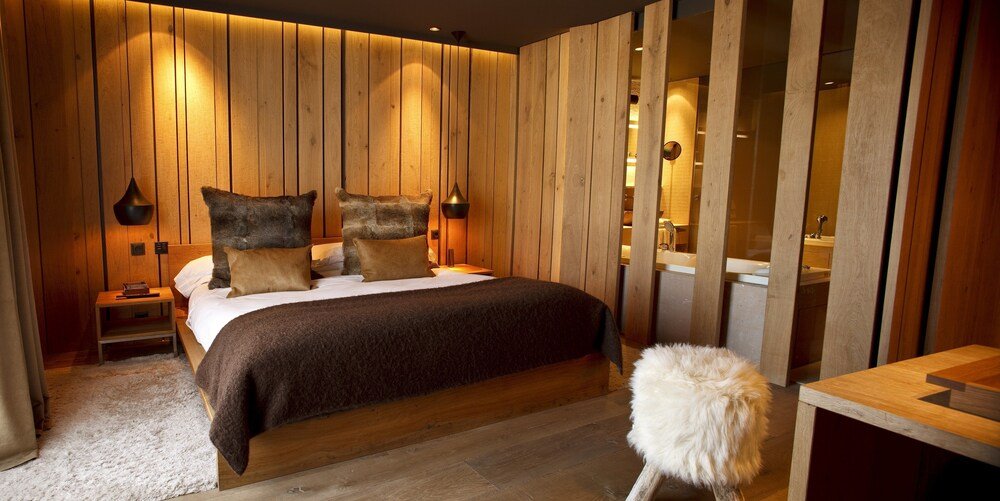 Bedroom with a wooden wall at the Grau Roig hotel