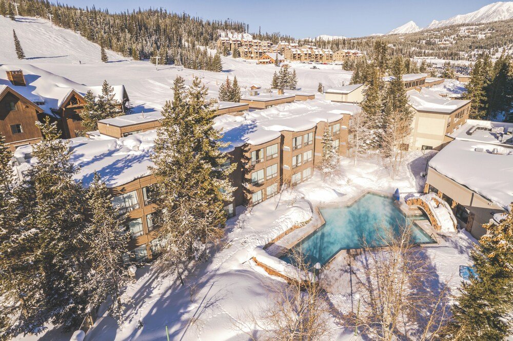 Resort with snow-covered grounds, a pool and lodge buildings