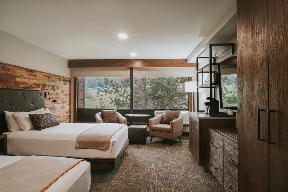 Hotel room with a large bed and two armchairs