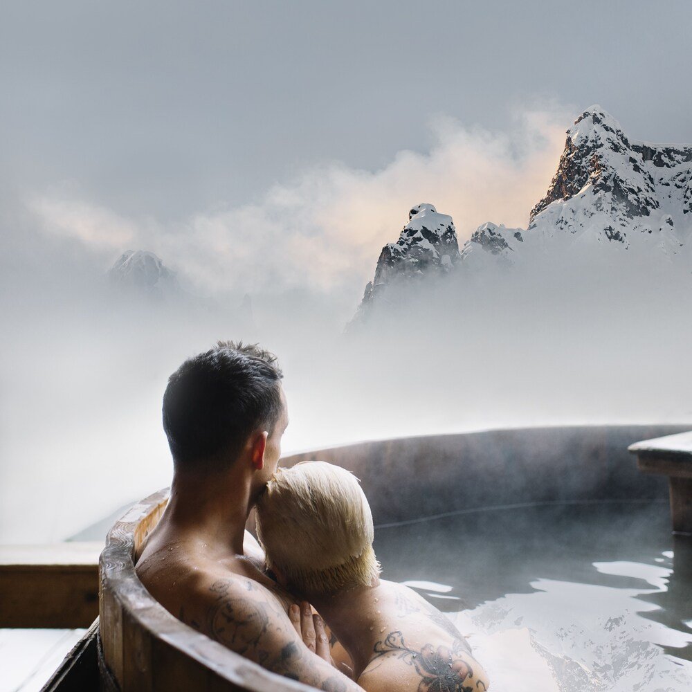 Couple relaxing in a hot tub at Mondschein Hotel and Chalet