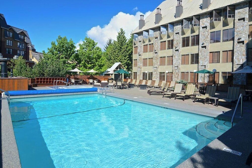 Piscina exterior con reposeras en el hotel de Whistler