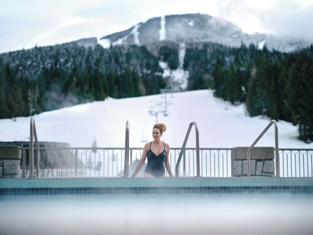 Outdoor pool with a view of the snowy mountain in Whistler