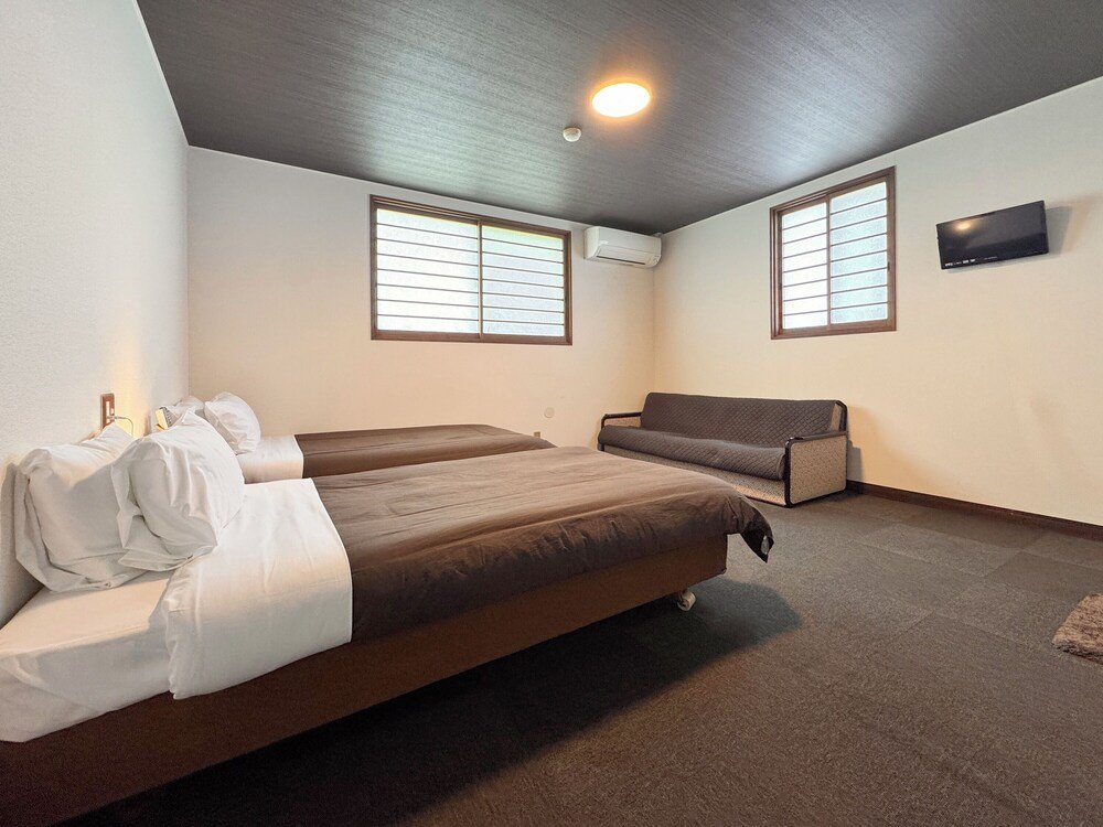 Bedroom with two beds and a sofa