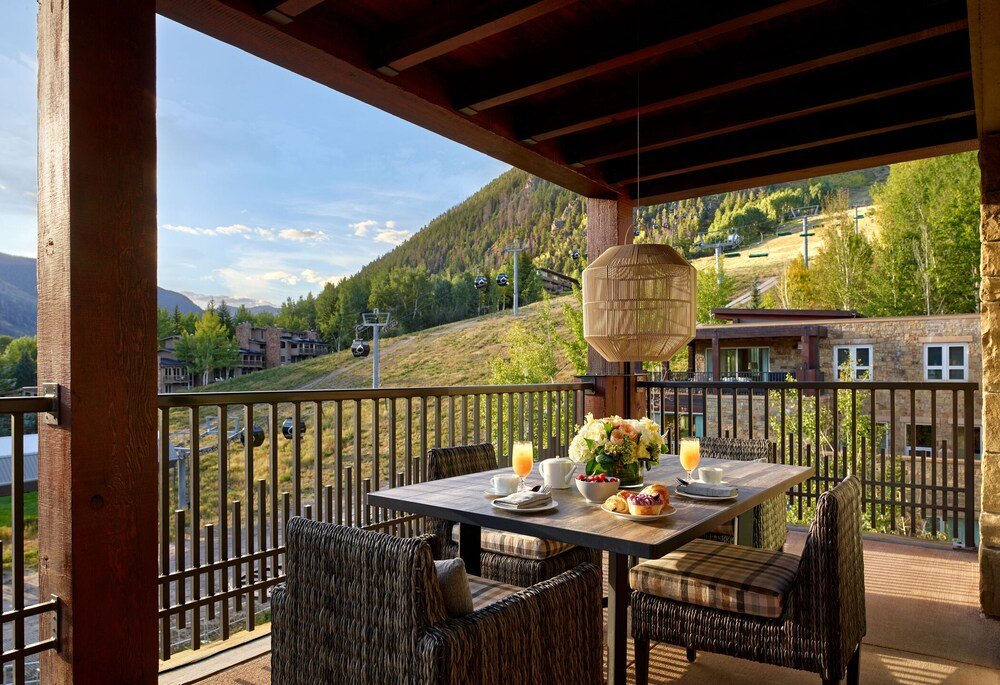 Comedor con sillas de mimbre en Residences at the Little Nell