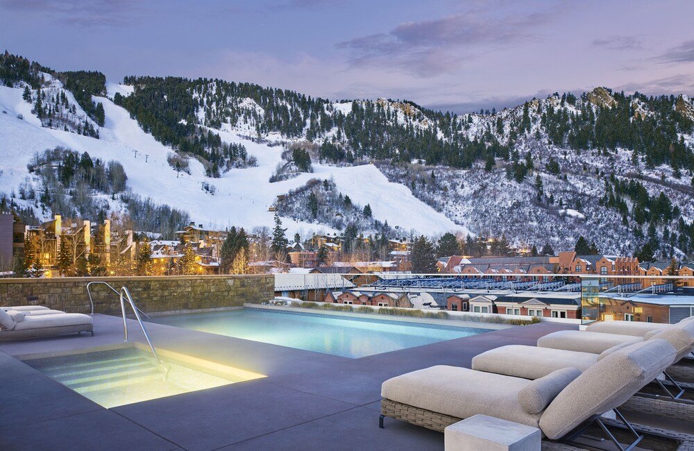 Zona de piscina con reposeras en Residences at the Little Nell