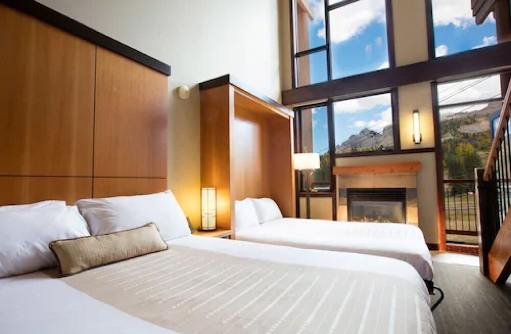 Hotel room with two beds and a fireplace