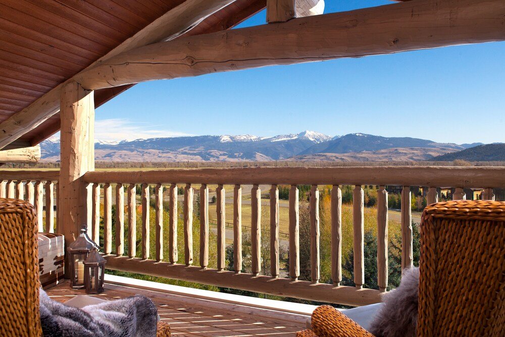 Wooden deck with wicker chairs at Teton Mountain Lodge