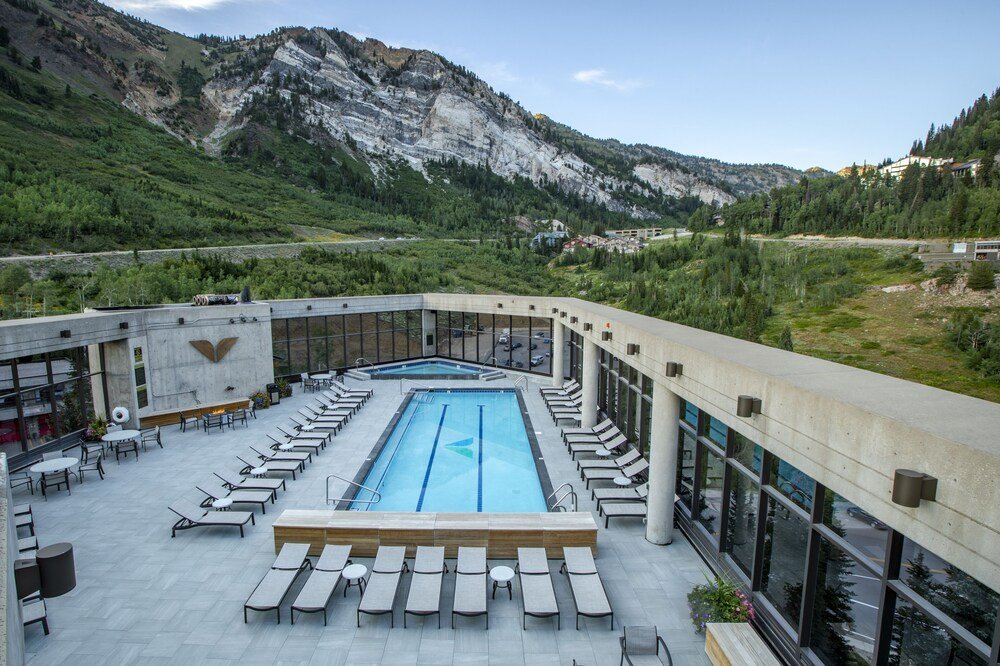 Rooftop pool with lounge chairs and mountain views