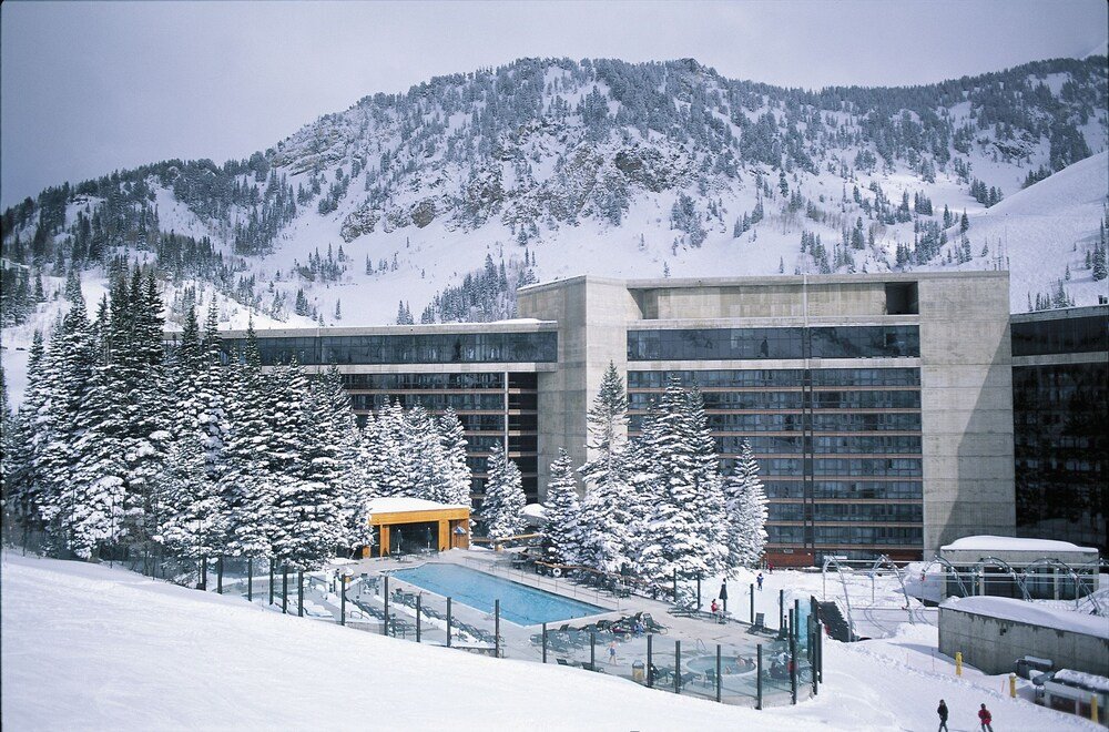 Modern building with a pool surrounded by snow-covered mountains
