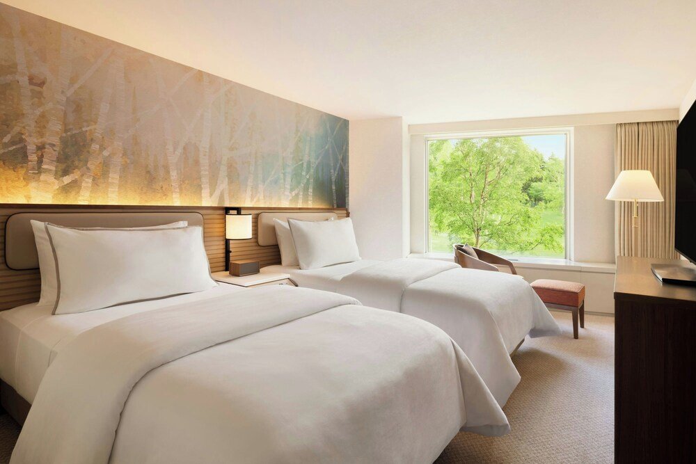 Hotel room with two beds and a large window
